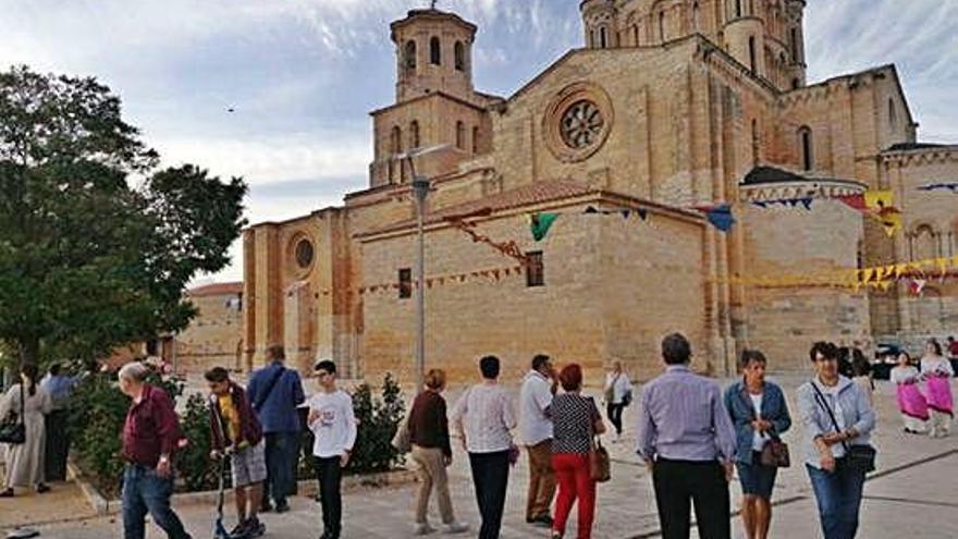 Visitantes pasean por el entorno de La Colegiata adornado para el mercado medieval de la fiesta.