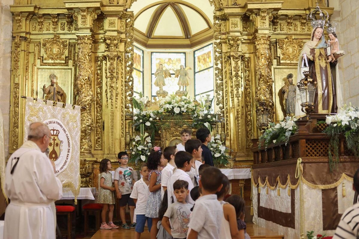 Los niños, en la iglesia junto al Virgen del Carmen.