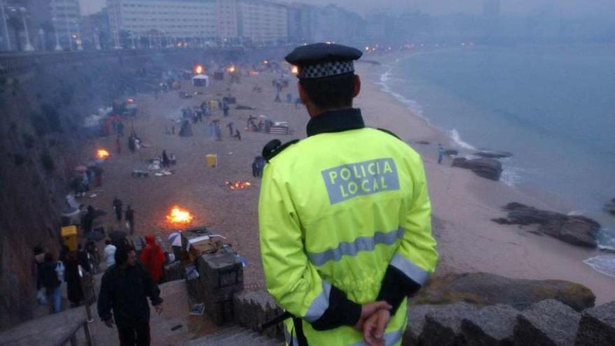 Un policía local vigila la playa del Orzán durante una celebración de San Juan.