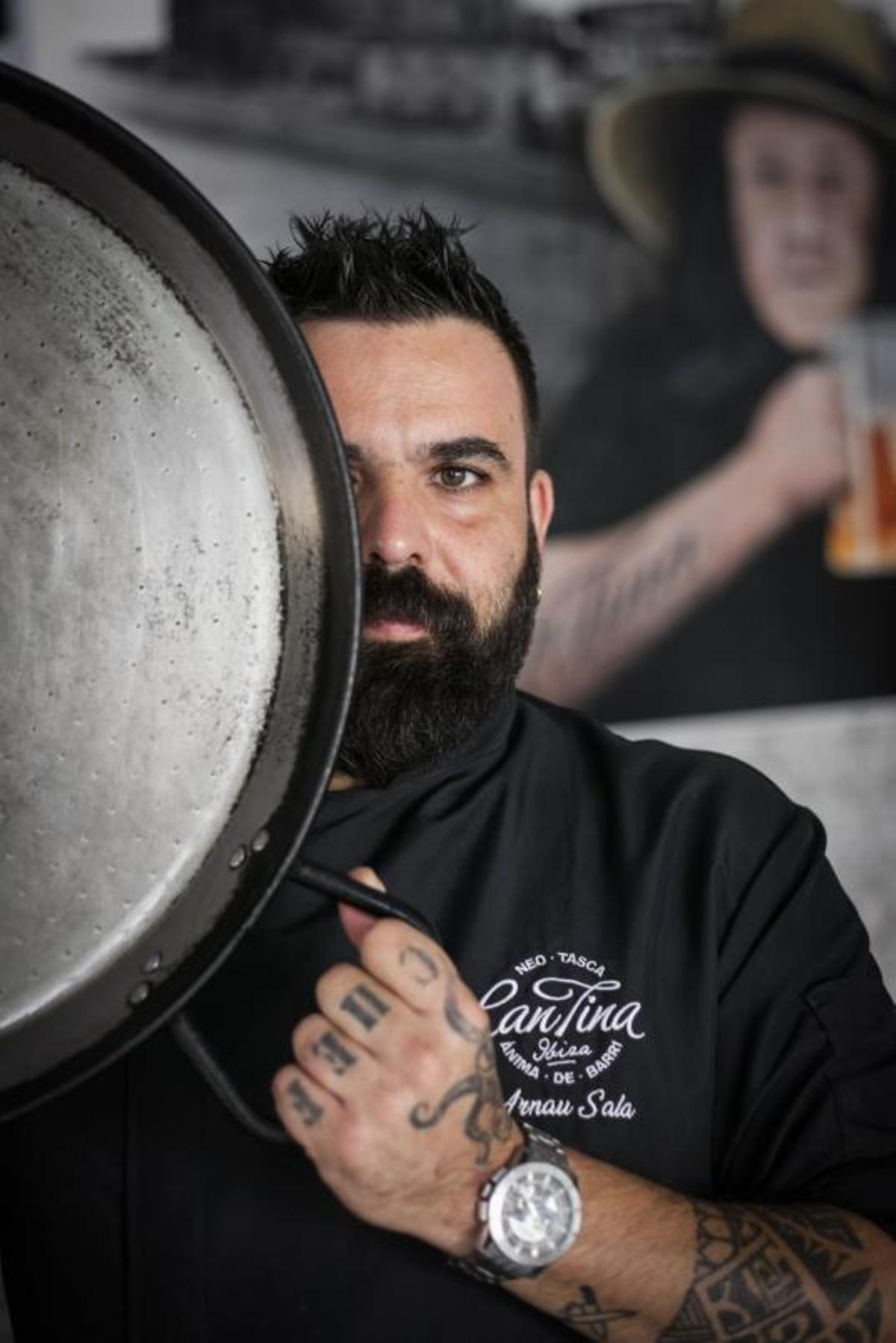 Arnau Sala, con una paella y La Tina, al fondo. | VICENT MARÍ