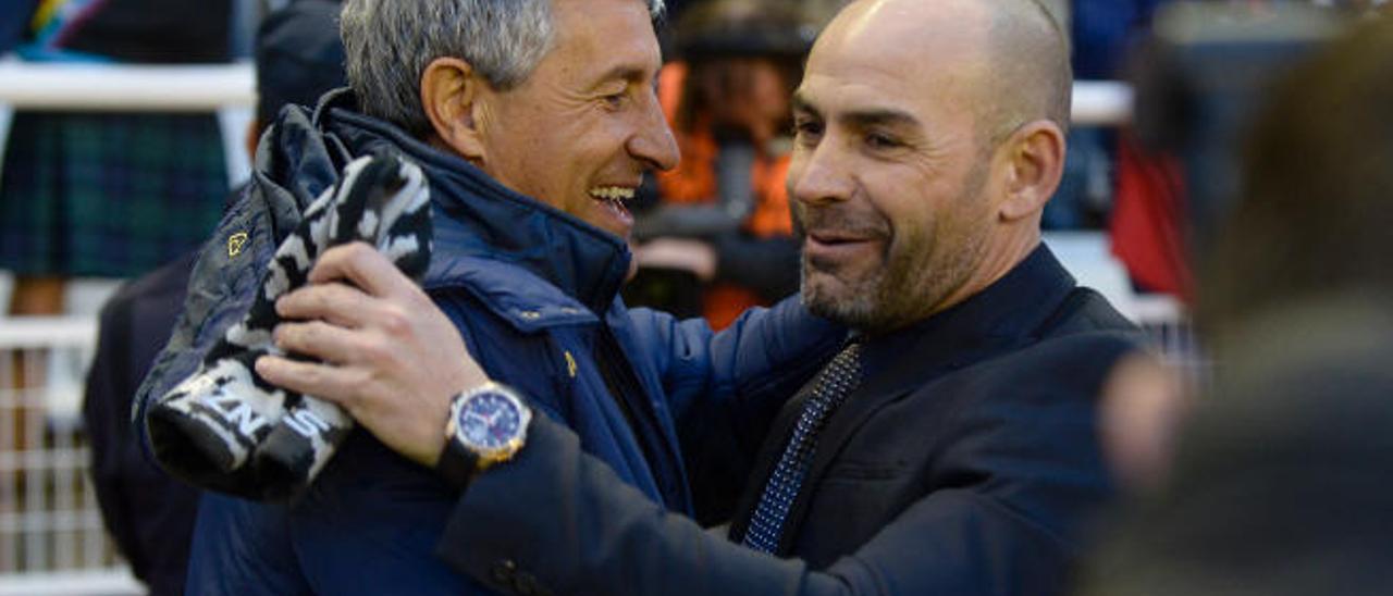 Los técnicos Quique Setién (i.) y Paco Jémez se saludan antes del pitido inicial, ayer en el Estadio de Vallecas.