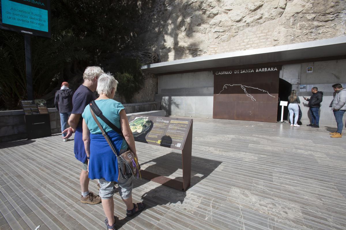 Turistas consultan los paneles informativos, con la puerta cerrada al fondo, este martes