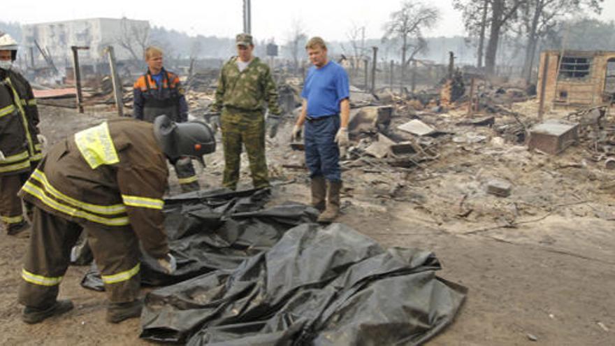 Bomberos guardan los cuerpos de las víctimas en bolsas, en la localidad rusa de Mokhovoye, a unos 170 kilómetros de Moscú.