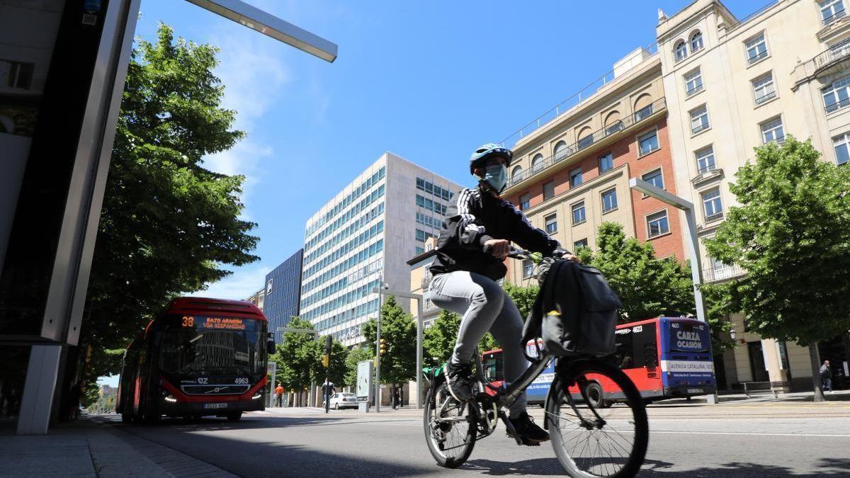 Un ciclista, delante de un autobús en Zaragoza.