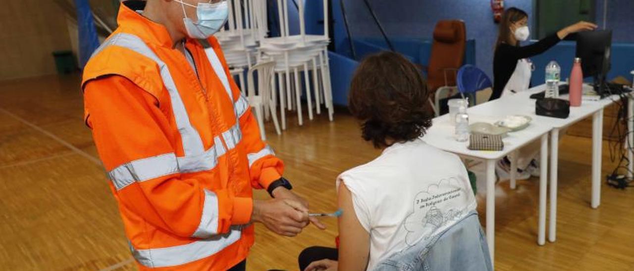 Un enfermero vacuna a un estudiante en el pabellón universitario. |   // PABLO HERNÁNDEZ GAMARRA