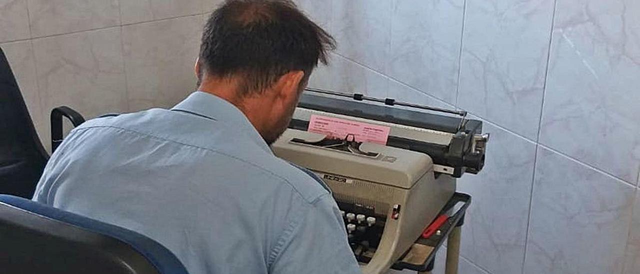 Un empleado del cementerio, ante la máquina de escribir.