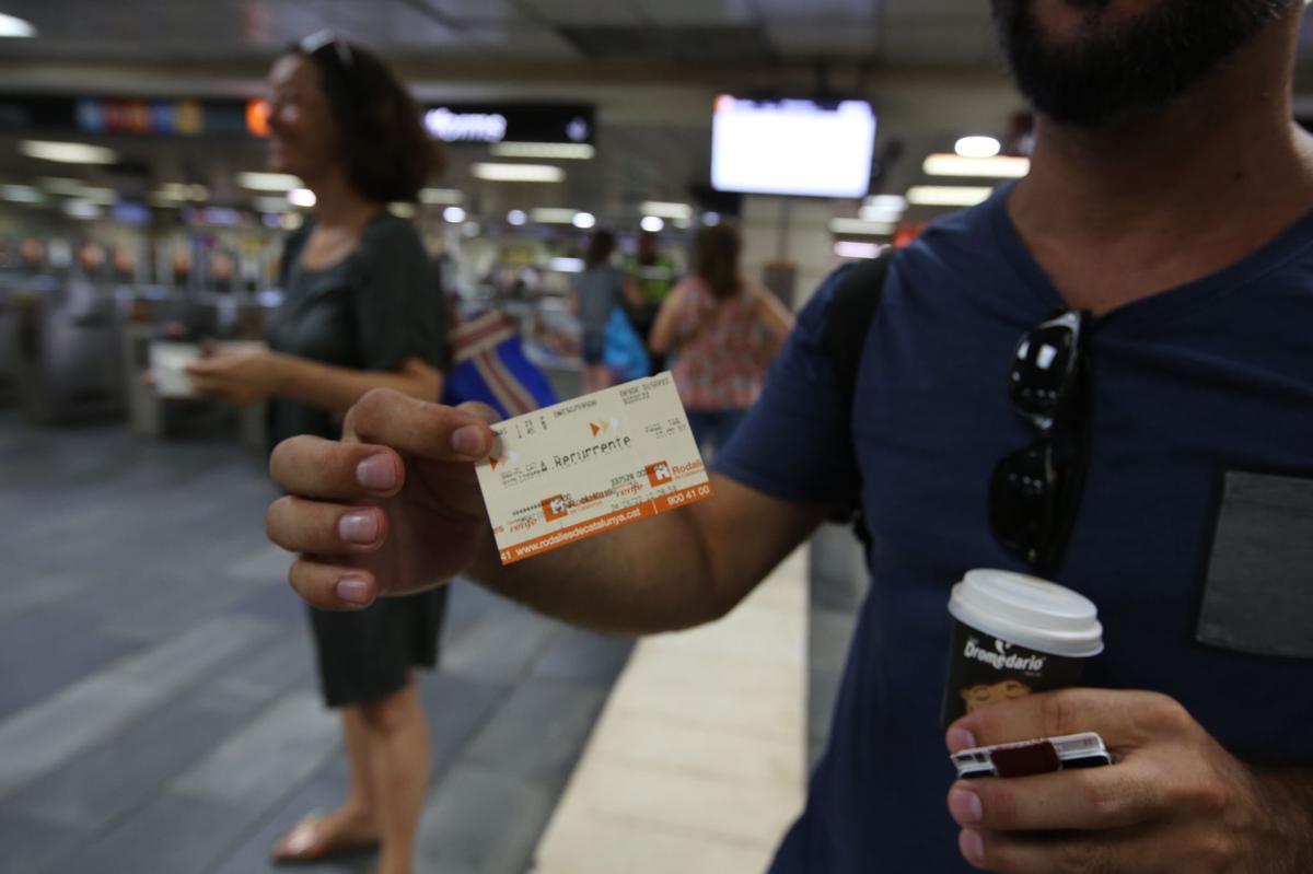 Usuarios de RENFE con el billete recién adquirido.