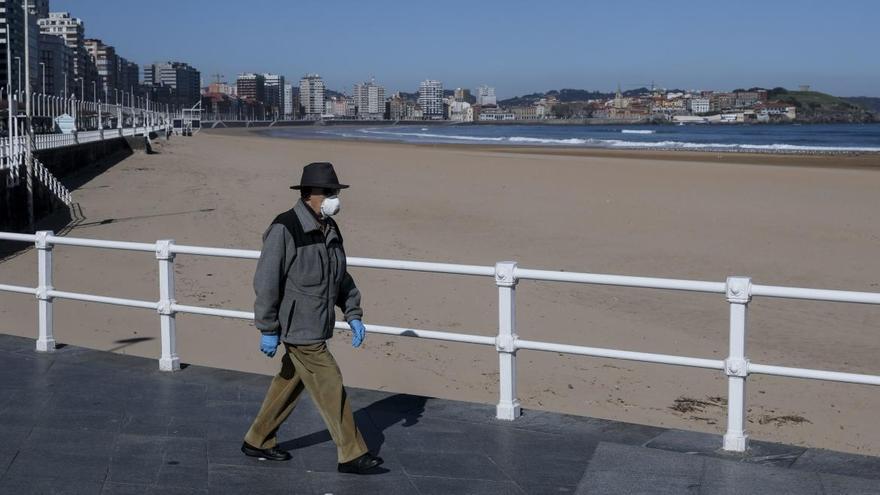 Un paseante por un desierto y soleado Gijón