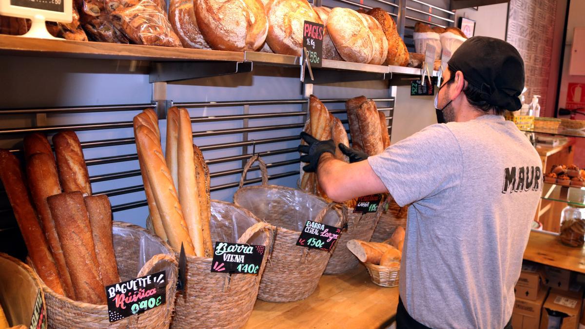 Un dependent posa barres de pa al forn de &#039;La Rovira&#039; a la plaça Rovira i Trias de Barcelona