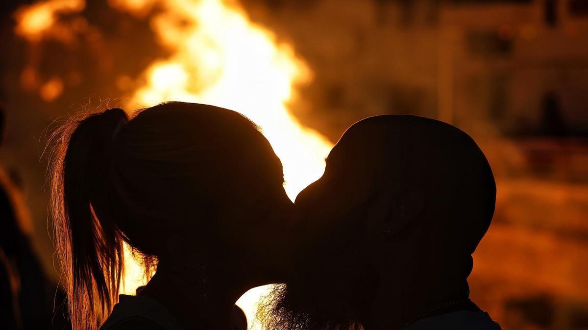 Un pareja se besa delante de una hoguera de San Juan en Santa Cruz de Tenerife.