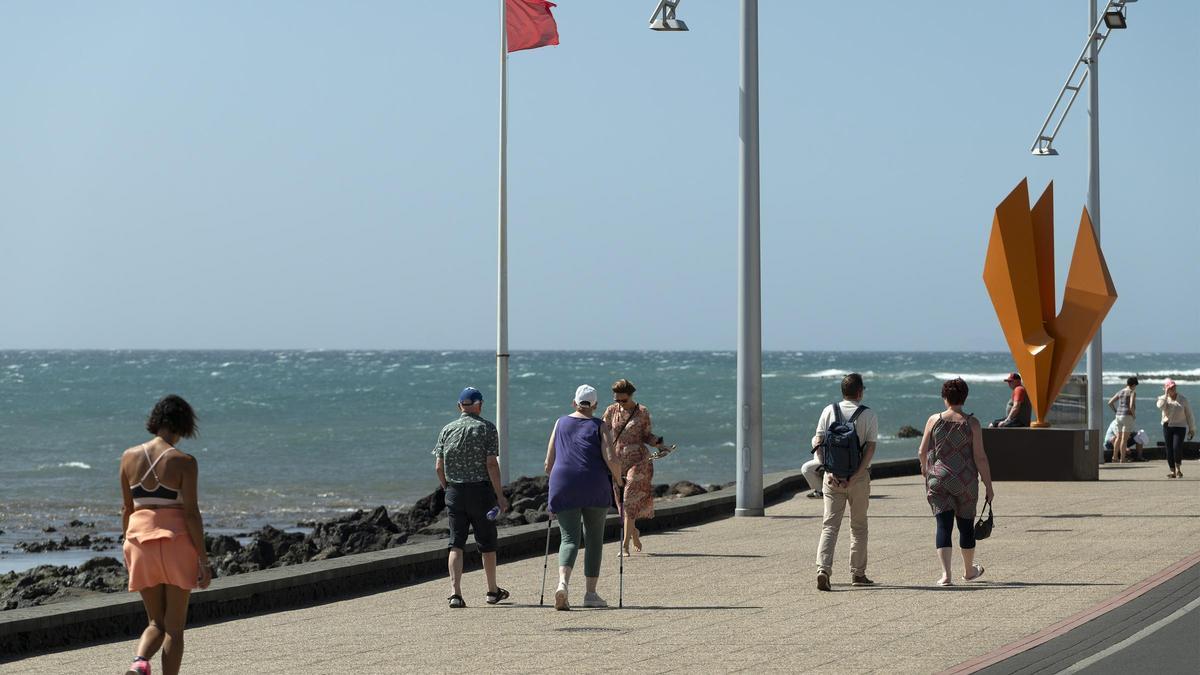 Turistas junto a la playa de Los Pocillos, en Puerto del Carmen.