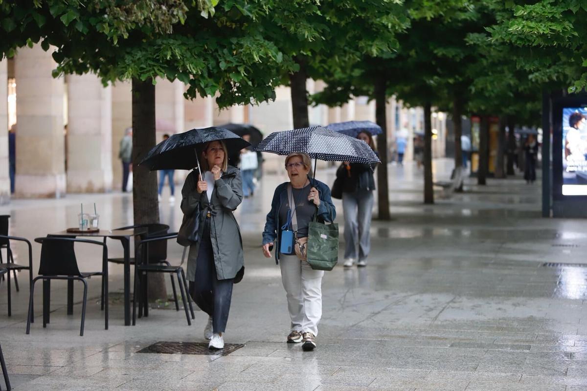 Dos mujeres se protegen de la lluvia en Zaragoza, en una imagen de archivo