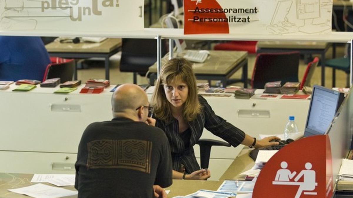 Una asesora laboral atiende a un ciudadano en el centro Porta22 de Barcelona Activa.