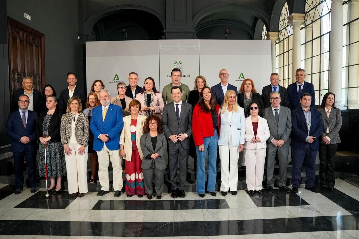 El presidente de la Junta, Juanma Moreno (c), junto a la consejera de Inclusión Social, Juventud, Familias e Igualdad, Loles López (6d), en una foto de familia tras presidir la reunión de coordinación con las entidades que componen el Comite Español de Representantes de Personas con Discapacidad (Cermi) en Andalucía.