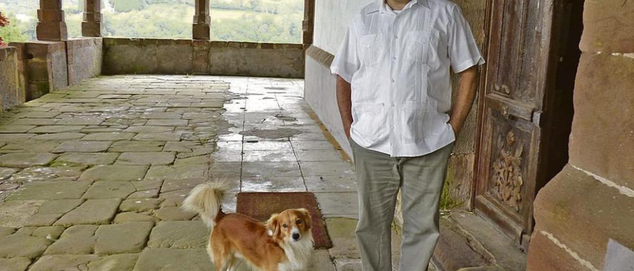 Rubén Pulido, en los soportales de la iglesia de Santolaya, el pasado julio, con su perro.