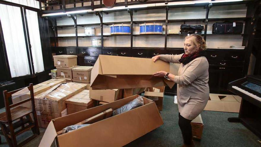 Pepa, la empleada del negocio, recogiendo unas cajas en el local. // Adrián Irago
