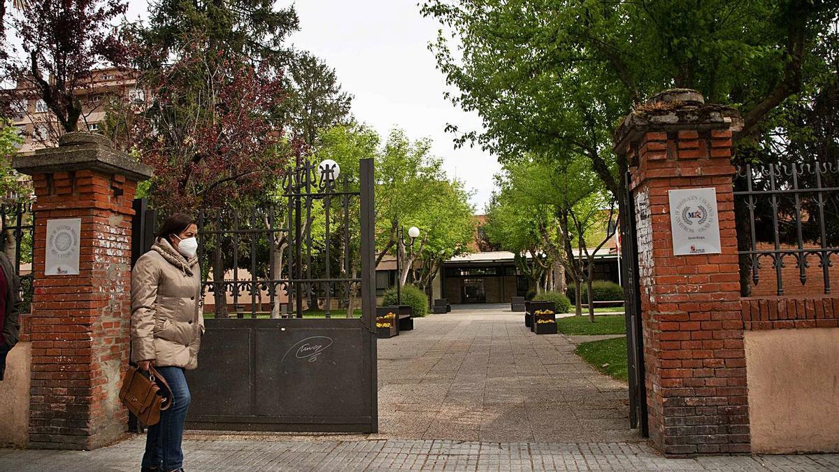 Una mujer pasa junto a la entrada del IES María de Molina.