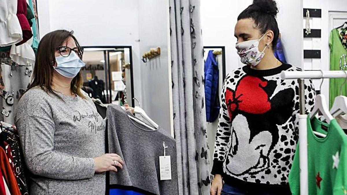  Belén Núñez, con una prenda en la tienda de moda de Carolina Martínez (a la derecha) en La Felguera.