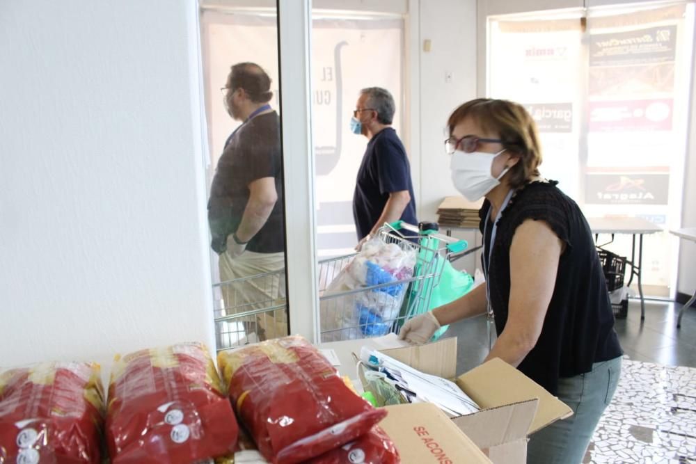 Preparativos y reparto de raciones para cocinar arroz al horno por el voluntariado de "Coronavirus amb Cor" de Alaquàs.