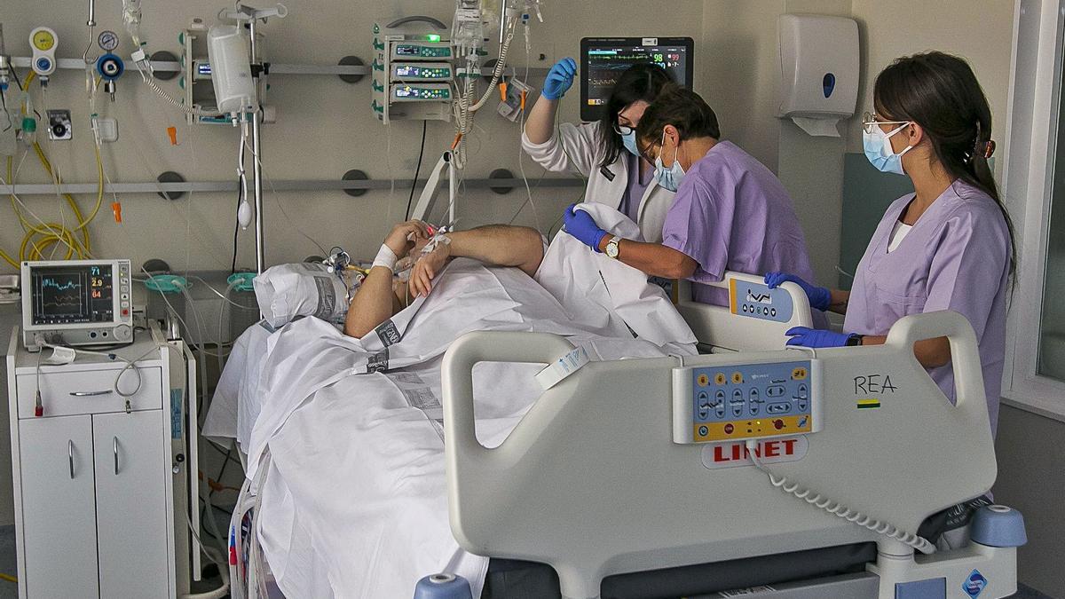 Personal del Hospital General atiende a un enfermo de covid que ya no está en aislamiento en unas de las nuevas camas. | HÉCTOR FUENTES