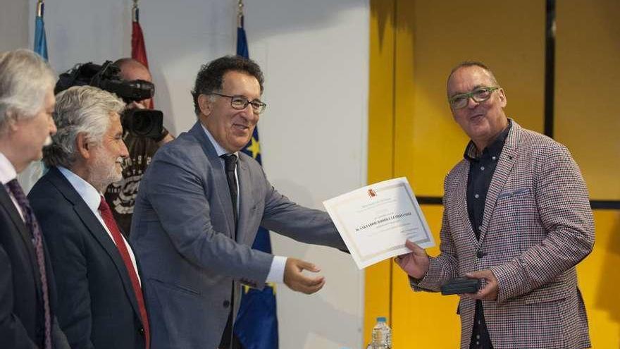 El presidente de la Audiencia, Antonio Piño, entrega la medalla de bronce a un funcionario. // Brais Lorenzo