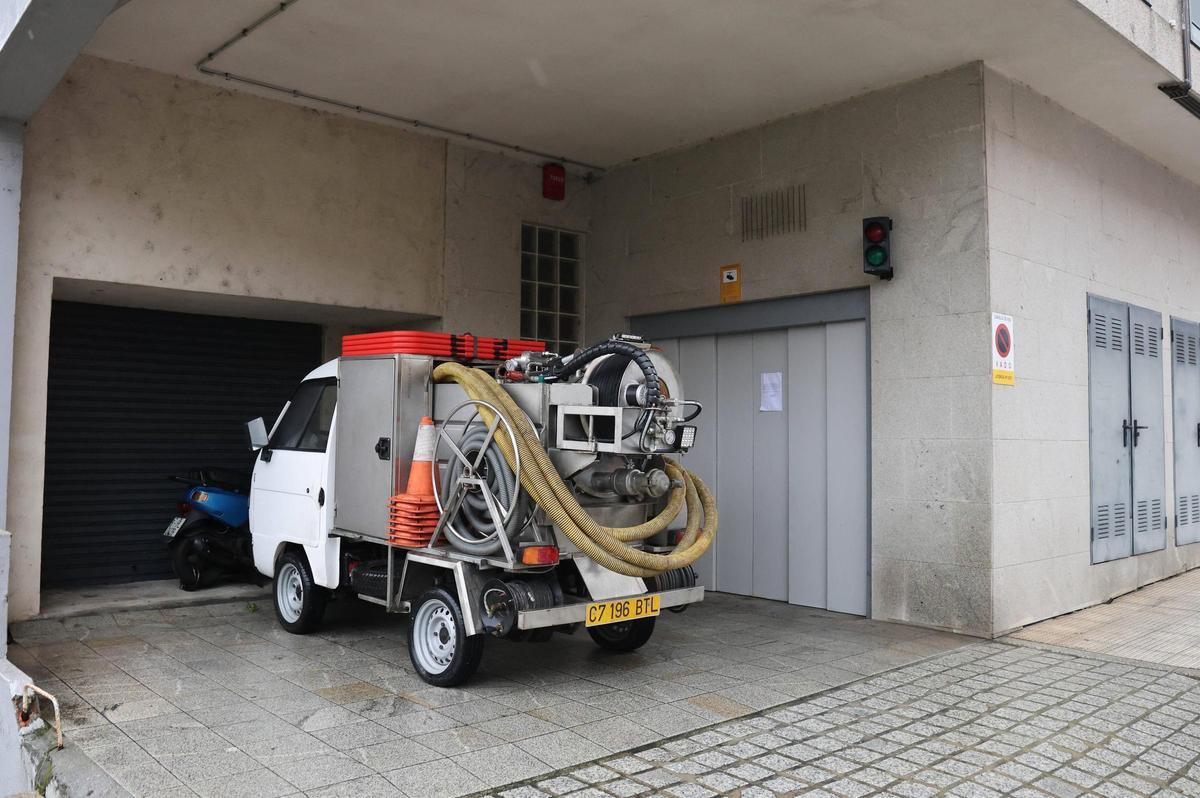 Un vehículo para extraer agua, ante un garaje estropeado en O Calvario.