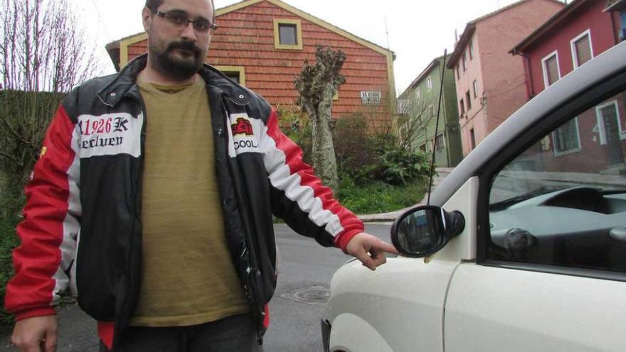 José María Gay Pérez señala uno de los retrovisores de su coche, roto tras un &quot;botellón&quot; en El Cuetu.