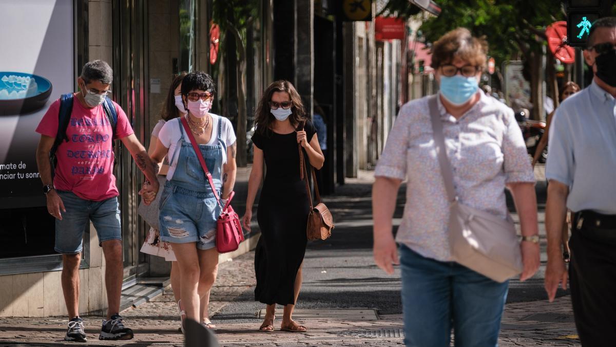 Varias personas con mascarilla caminan por Santa Cruz de Tenerife.