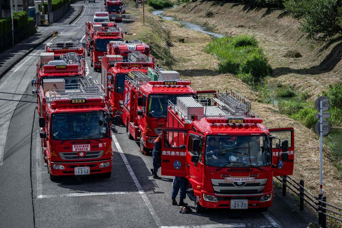 Los vehículos de emergencia se ensamblan fuera del molino Yatsushiro de Nippon Paper Industries en Yatsushiro, prefectura de Kumamoto, el 29 de julio de 2026, después de que un terremoto sacudió el suroeste de Japón el día anterior. (Foto de Yuichi YAMAZAKI / AFP)
