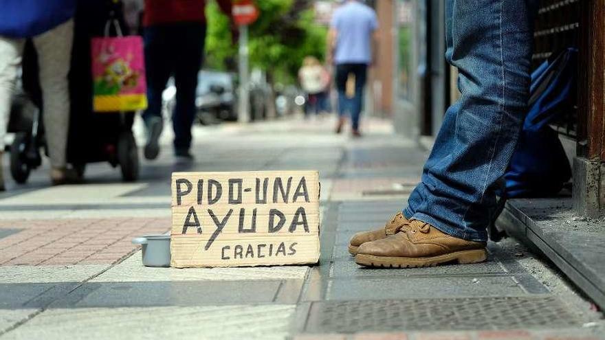 Un hombre pide en la calle.