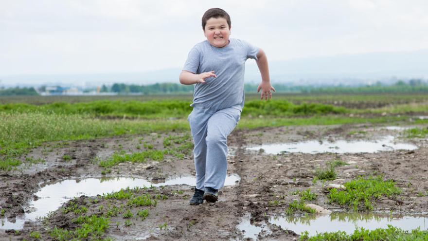 Niño con sobrepeso haciendo deporte.