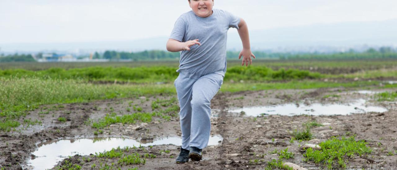 Niño con sobrepeso haciendo deporte.