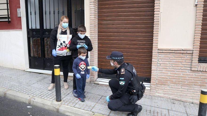 Un Policía Local se acerca a un niño durante el confinamiento.