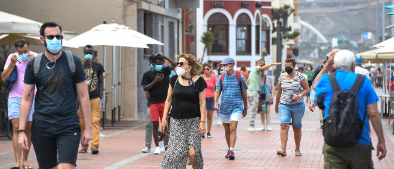 Gente con mascarilla en el paseo de Las Canteras.