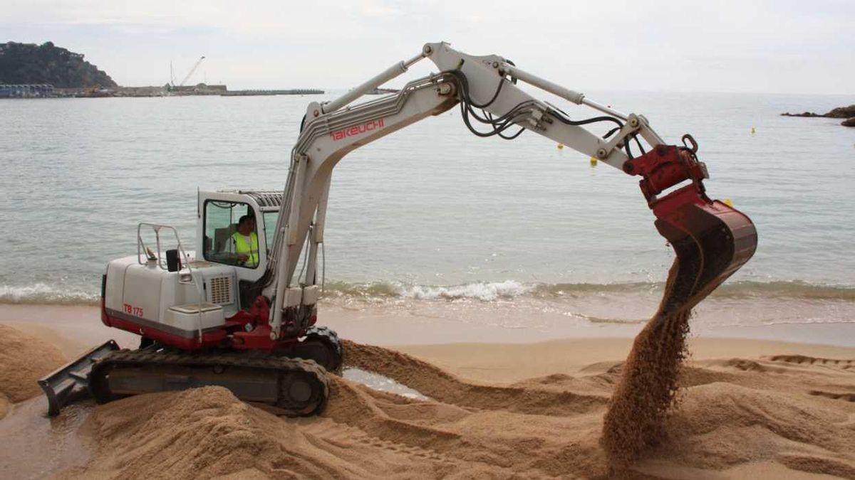 Unes màquines s'encarreguen de moure i aplanar la sorra per tal de reomplir aquells punts de la platja de Blanes que s'ha quedat sense a causa dels temporals.