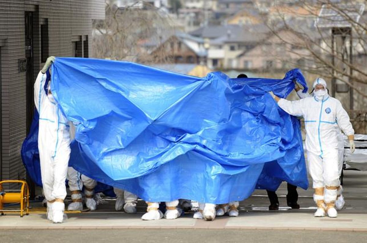 Treballadors de la planta de Fukushima traslladen, coberts per una lona, els dos operaris que van trepitjar aigua contaminada, dijous. Treballadors de la planta de Fukushima traslladen, coberts per una lona, els dos operaris que van trepitjar aigua contaminada, dijous.