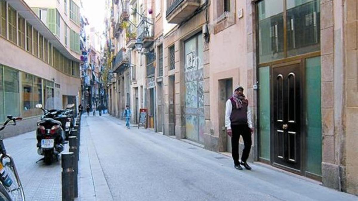 Un hombre pasa ante la puerta de un hostal ya cerrado en la calle D'en Roig, ayer.