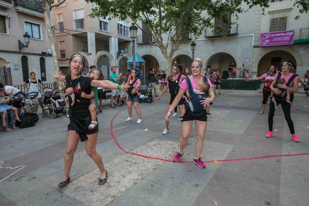 Un grupo de madres representa la canción central del musical «Mamma Mia» en la plaza de El Raval porteando a sus bebés