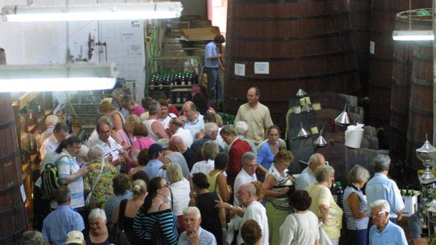 Los visitantes se arremolinan en la zona de degustación de la bodega.