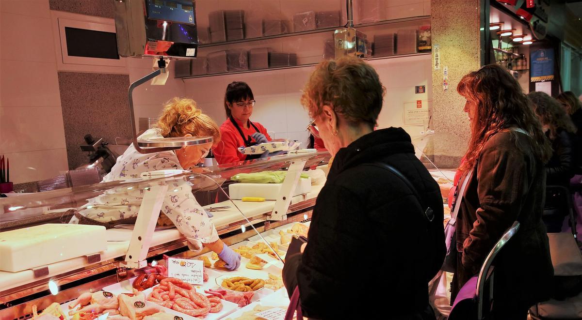 Dos clientas realizan la compra en una parada del Mercat del Centre de L'Hospitalet de Llobregat.