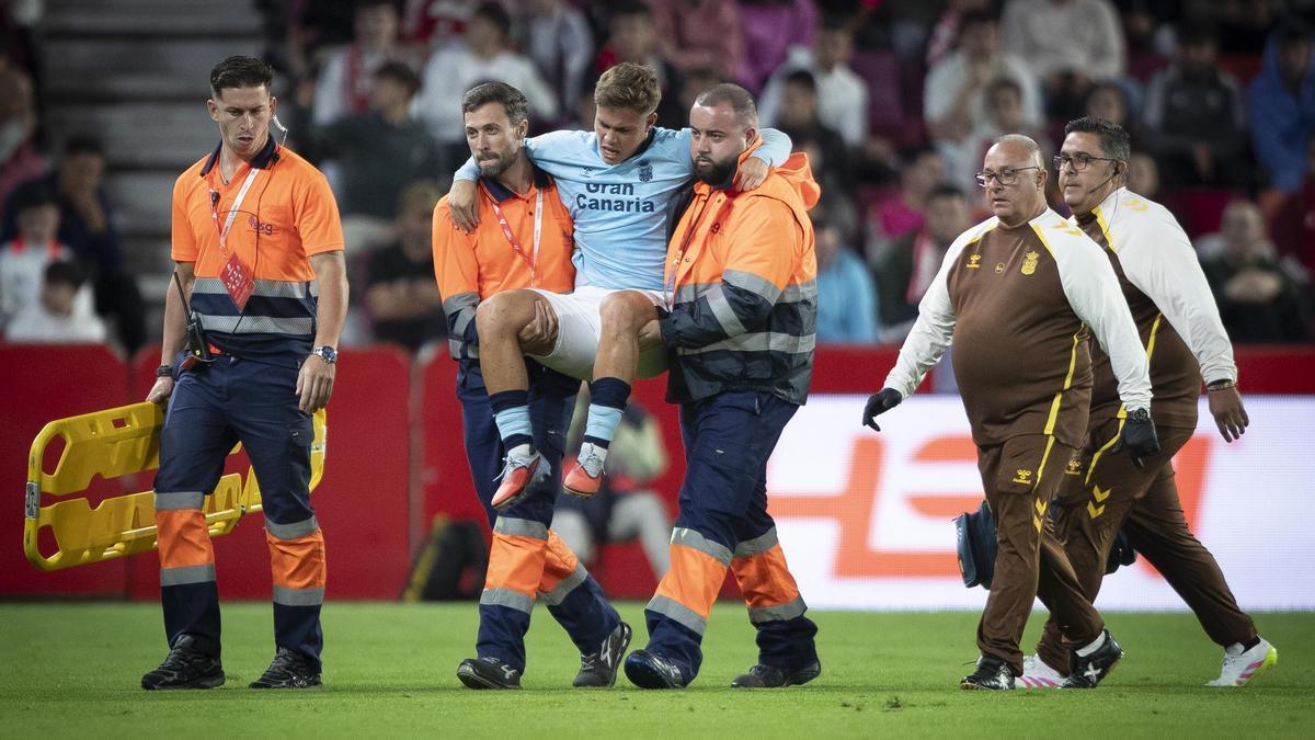 Recoba abandona el césped lesionado ayudado por los servicios de emergencia.