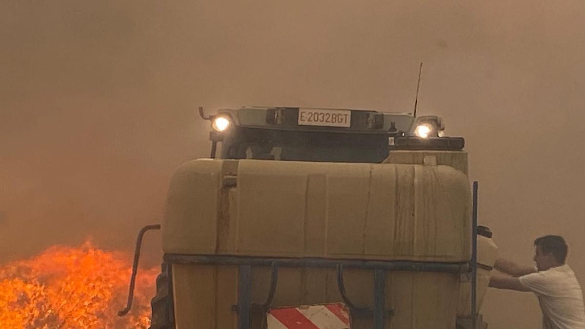 Ángel Bonel, el alcalde de Vera, sube a un tractor con una bomba de agua con el fuego junto a la rueda.