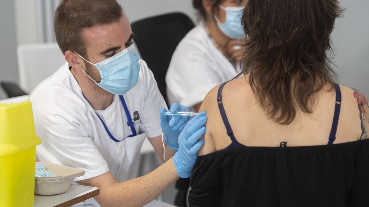 Una joven recibe la primera dosis de la vacuna Pfizer.