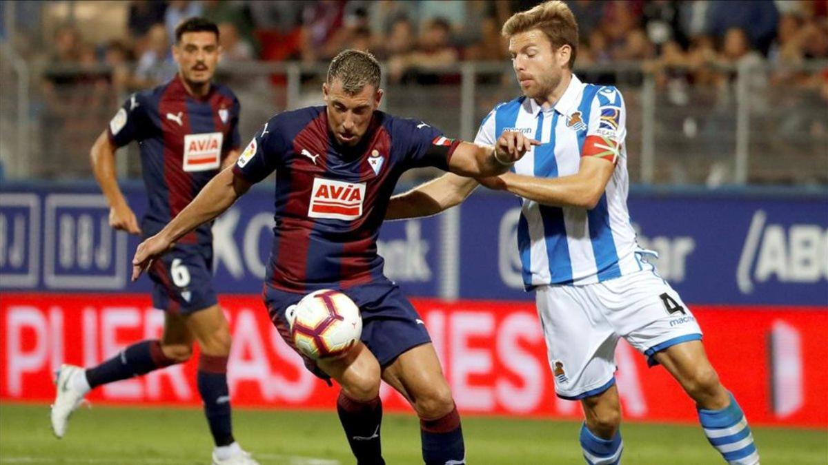 El centrocampista de la Real Sociedad Asier Illarramendi lucha un blón con Sergi Enrich