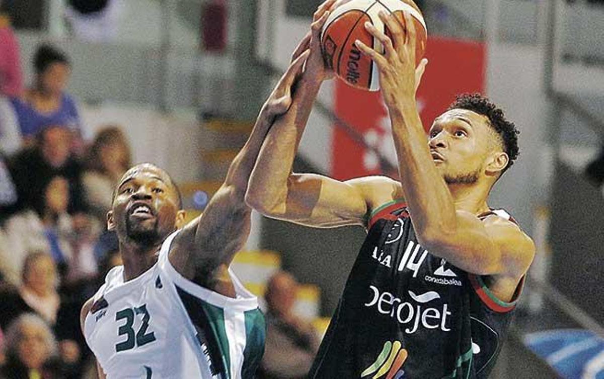 El alero estadounidense Marcus Gilbert, que anotó dieciocho puntos, entra a canasta ante la oposición del visitante Daniel Sapp.