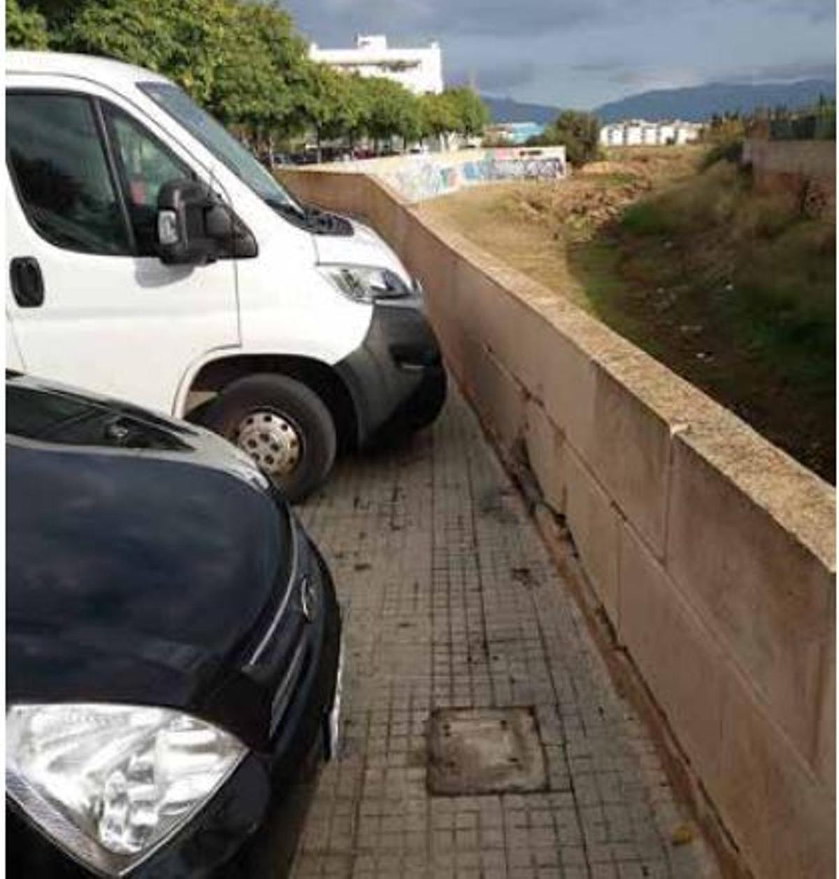 Los vecinos piden la colocación de bolardos para que los coches no aparquen junto al muro.