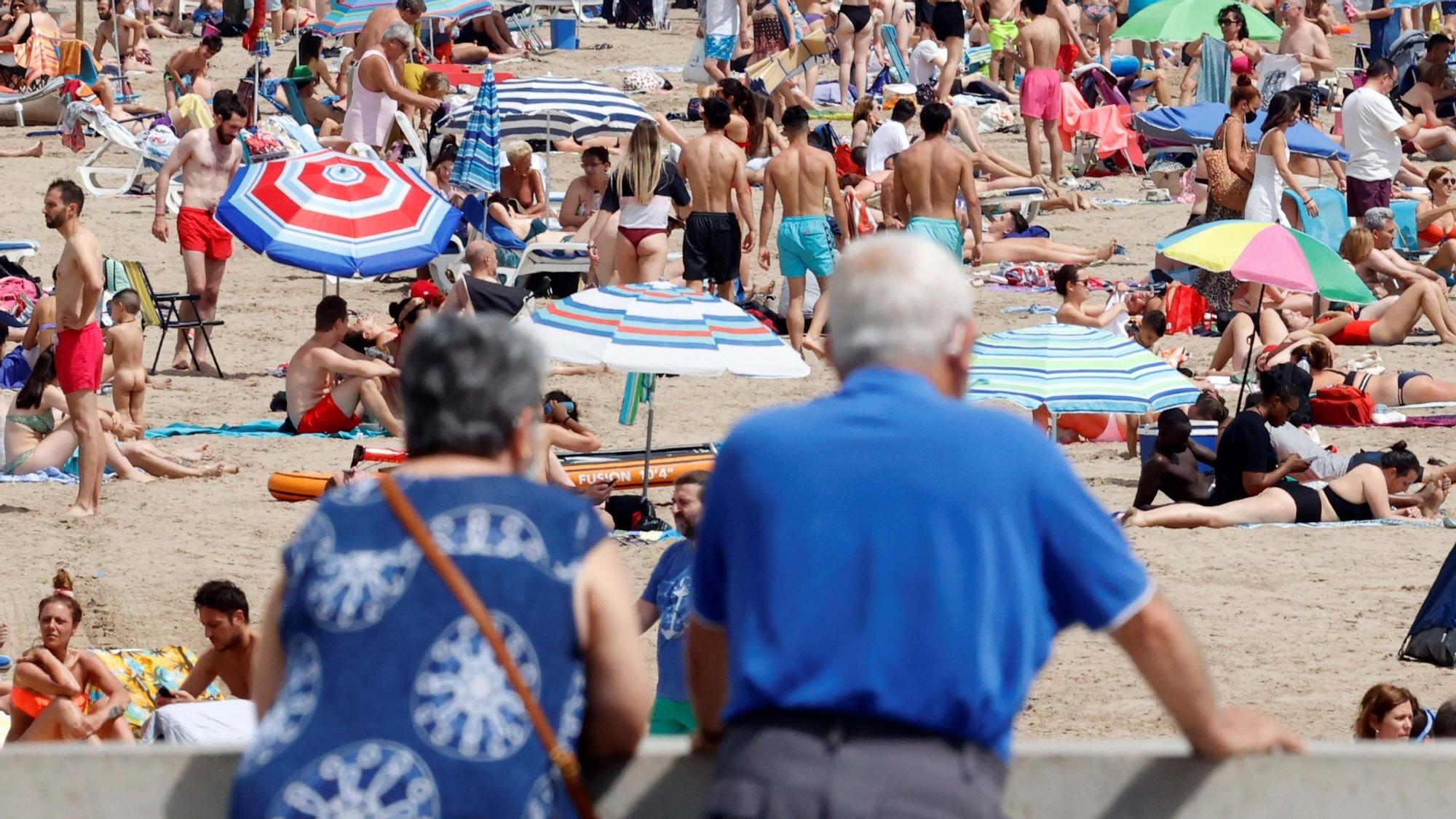 Una pareja de ancianos contempla una playa