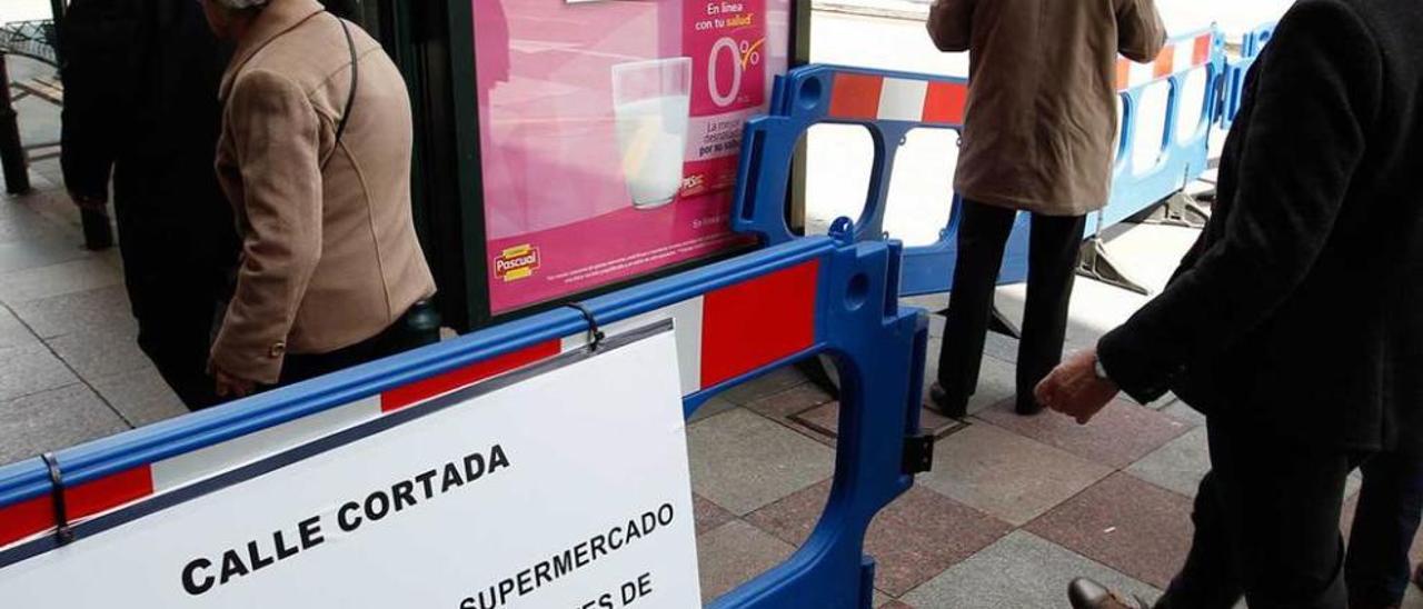 Una de las vallas que limitan el acceso a la calle Uría.