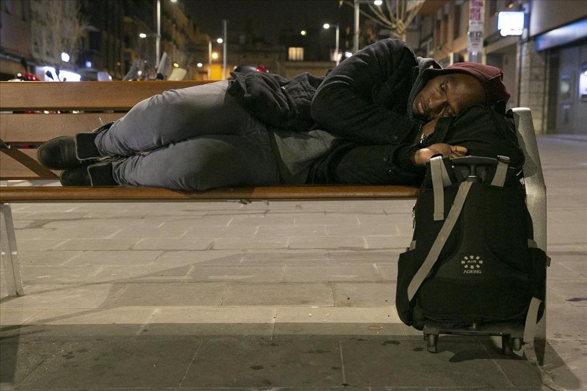 Julien es un inmigrante que duerme en un banco del Poblenou, Barcelona, a la espera de encontrar un alojamiento social.