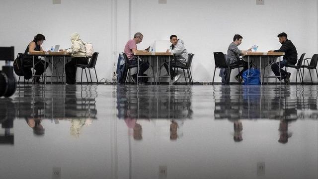 Sol·licitants del procés de regularització tramiten els papers en una oficina de l’Hospitalet. | FERRAN NADEU